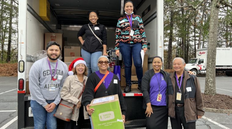 Group moving boxes outside of truck