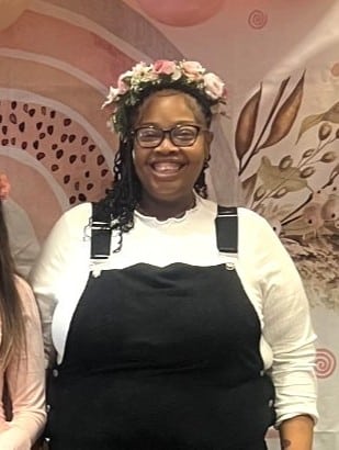 A mother in a flower crown posing at her baby shower