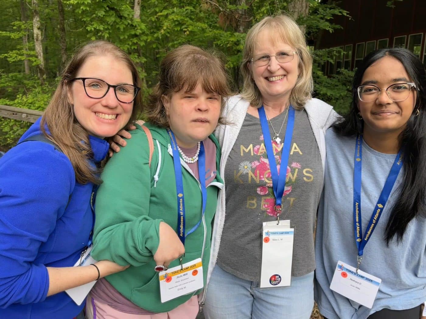 4 girls wearing lanyards smile for the camera