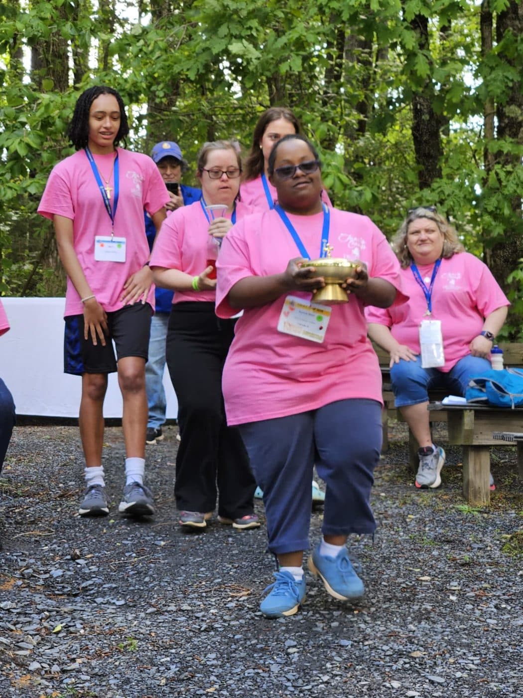 Two campers process down the aisle carrying gold vessels