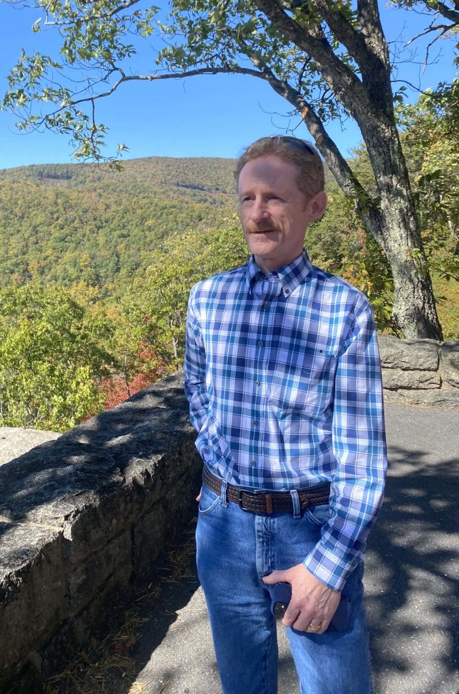 A man standing outside in nature looks into the distance
