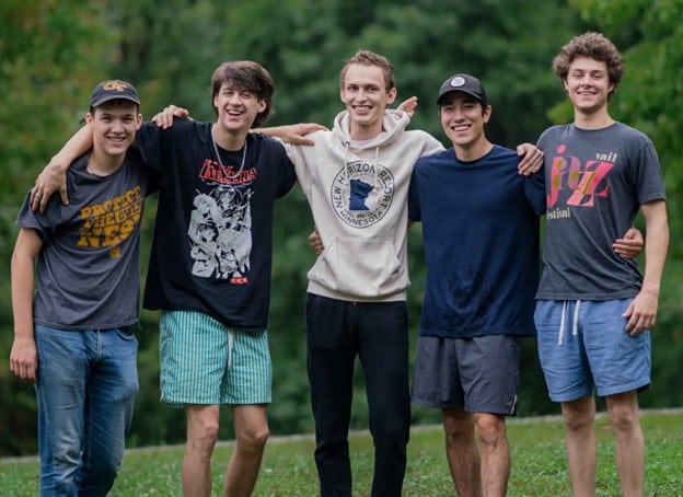 Group of male students pose on a field