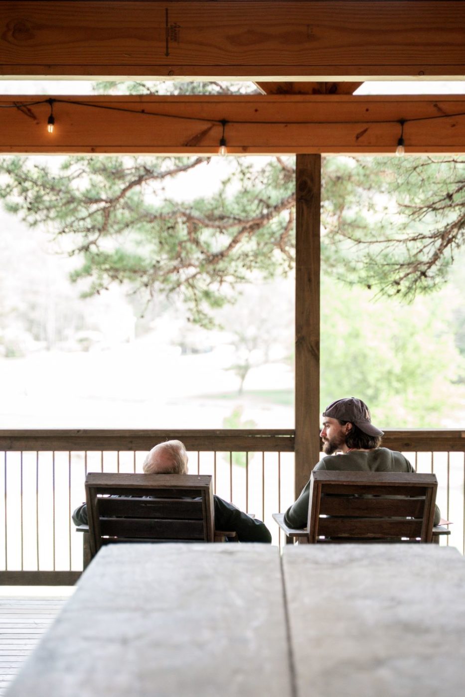 two people engage in a private conversation in front of a scenic overlook