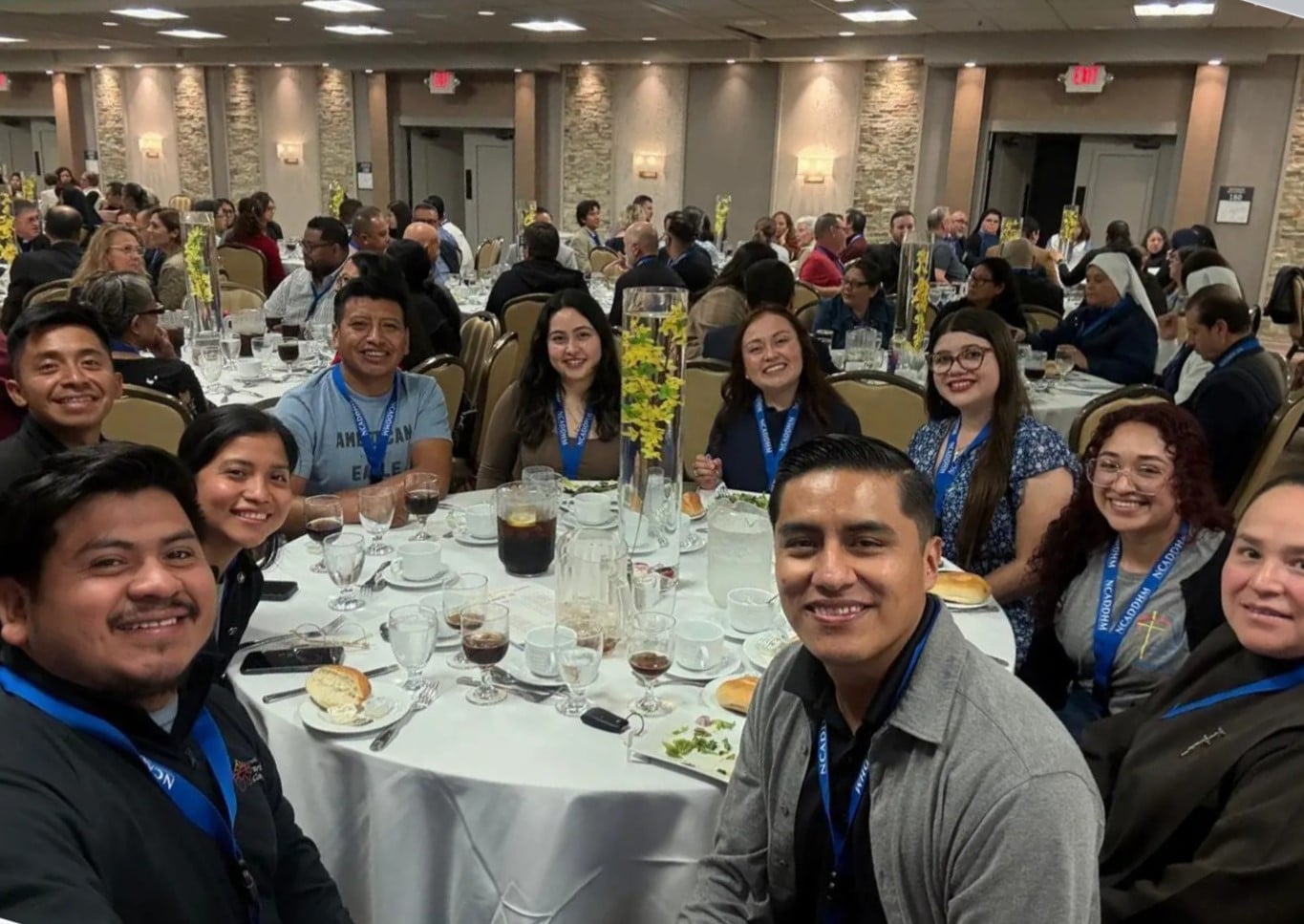 A group of people smile while sitting at a round table