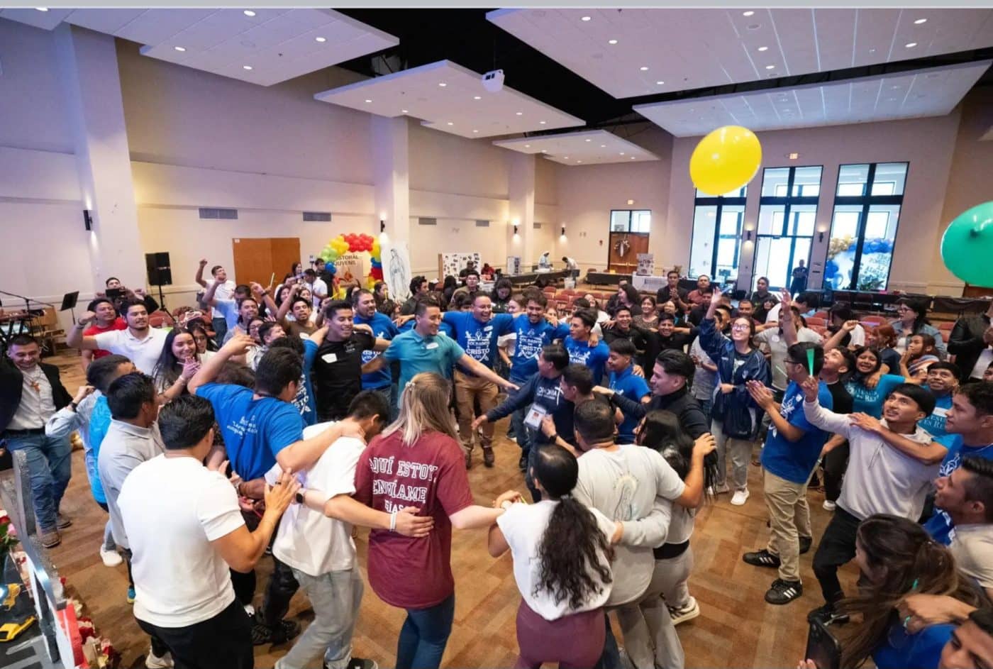 Many people dance surrounding a smaller group dancing in a circle