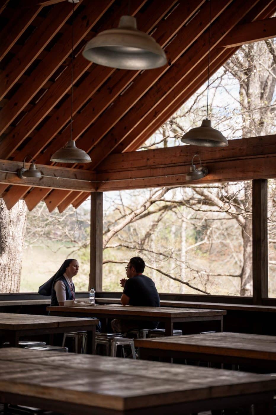 Two people speak in private under a pavillion