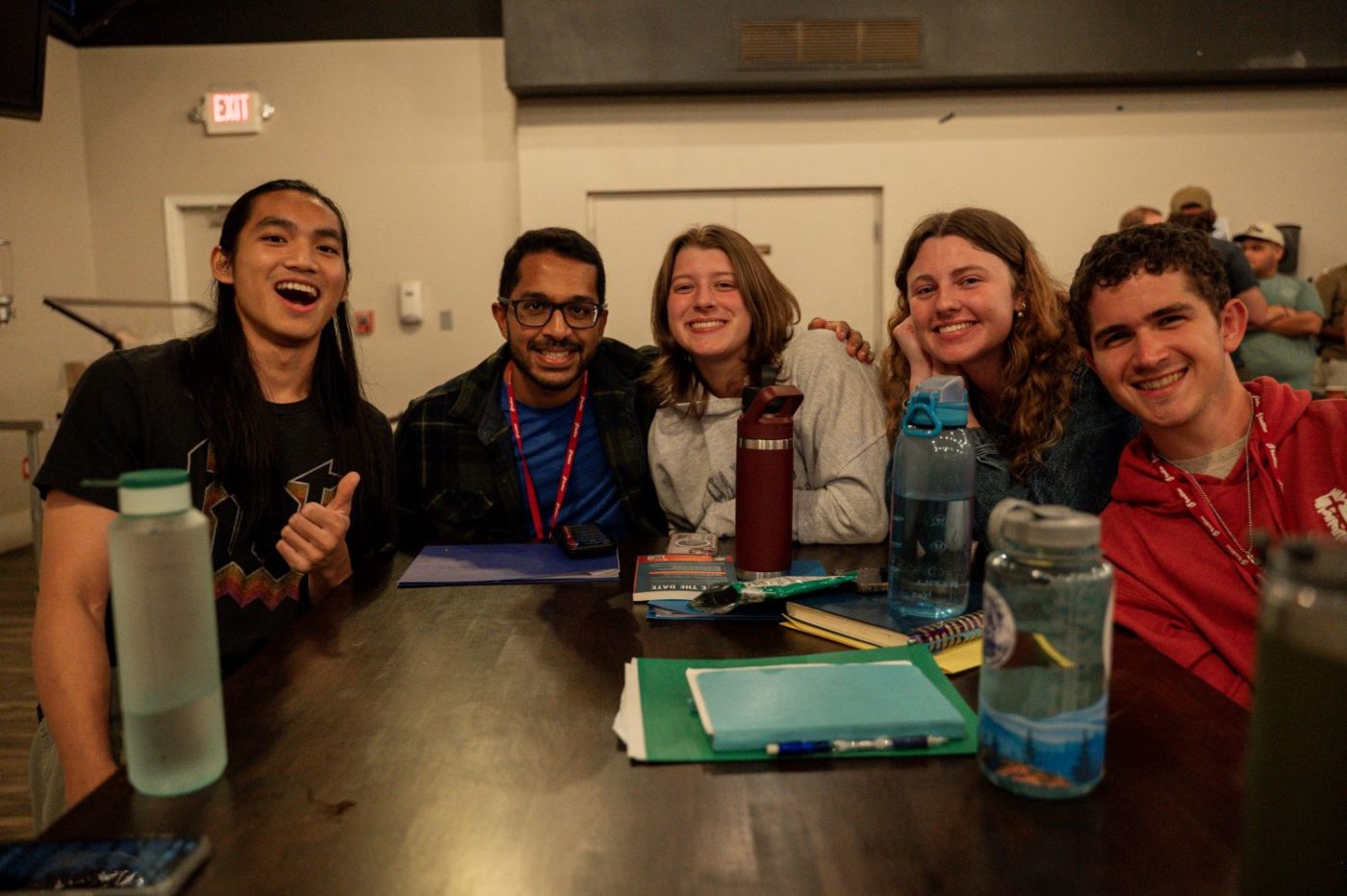 5 young people smile at a table
