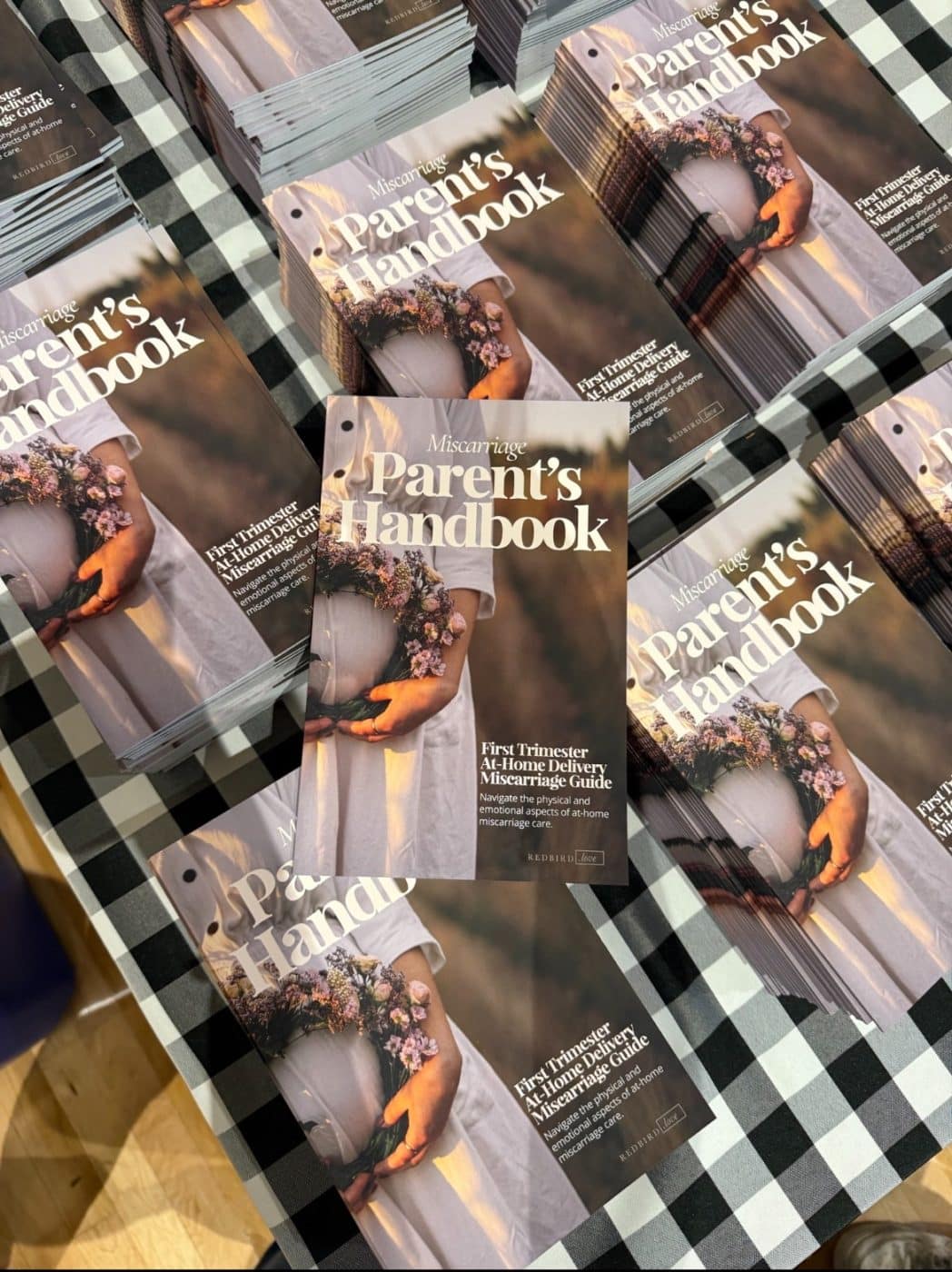 stacks of a book titled "Miscarriage Parent's handbook"