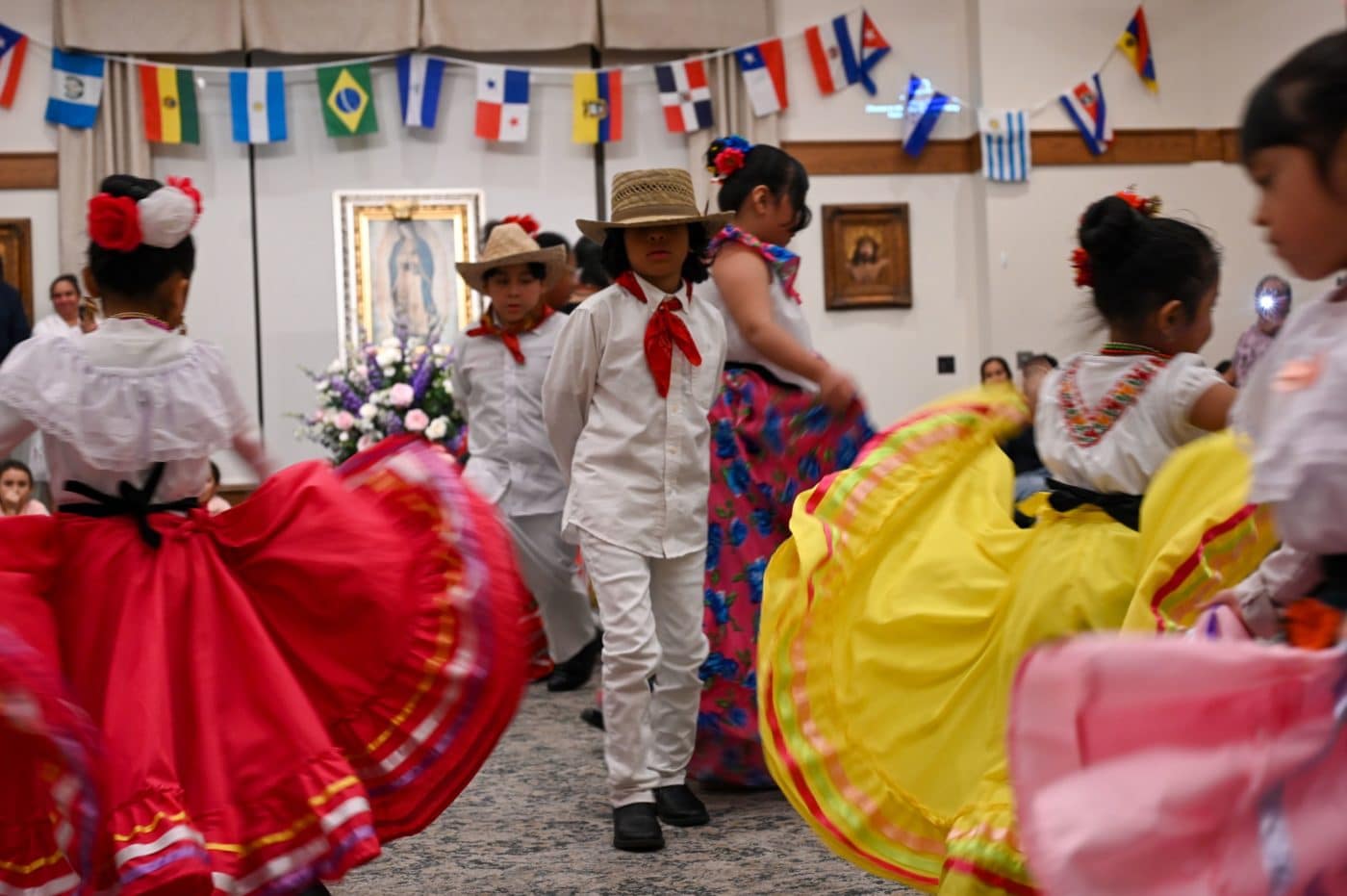 Children dance in vibrant cultural outfits