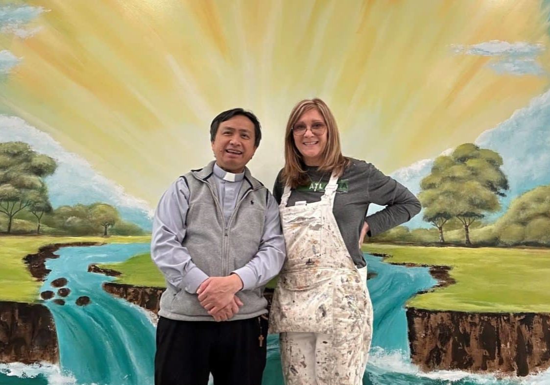 Father Henry Pham And Caroline Camick In Front Of Mural At St. Mary Toccoa