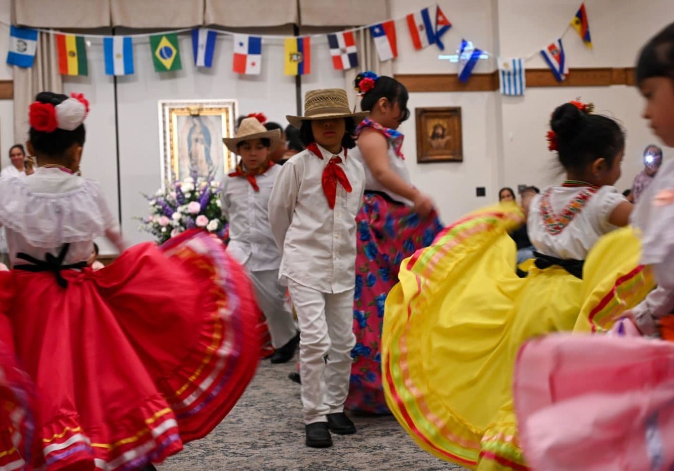 Children dance in vibrant cultural outfits